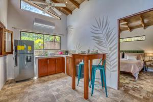 a kitchen with a refrigerator and a table and stools at Hotel Villas Tangerine in Sámara