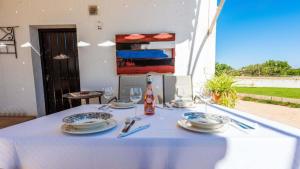 een tafel met een witte tafeldoek en borden erop bij Casa Rural Viña Meneses in Marchena