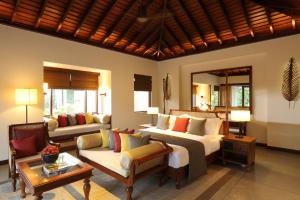 a bedroom with a bed and a living room with a couch at Anantara Peace Haven Tangalle Resort in Tangalle