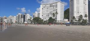 a group of people on a beach with buildings at Apartamento Guarujá Pitangueiras 50 metros Praia/3 Dormitórios/Vista do Mar, Sol da manhã in Guarujá