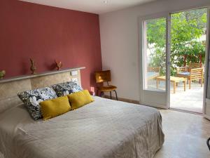 een slaapkamer met een bed en een glazen schuifdeur bij Casa di Floumy in Calvi