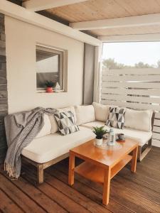 a living room with a white couch and a table at Mobile Home Aloha in Tisno