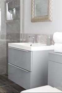 bagno bianco con lavandino e specchio di Mystique Barn a Bristol