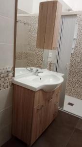 a bathroom with a sink and a mirror at Appartamenti turistici Aprile Antonio Luigi in Borgagne