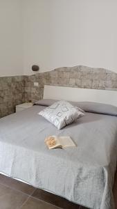Un dormitorio con una cama con un libro. en Appartamenti turistici Aprile Antonio Luigi, en Borgagne