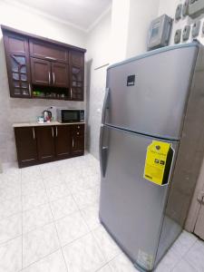 a kitchen with a refrigerator with a yellow sign on it at Nile view apartment in Cairo