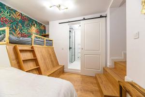 a bedroom with a bed and stairs with a door at Rope Street eState Picturesque in Braşov