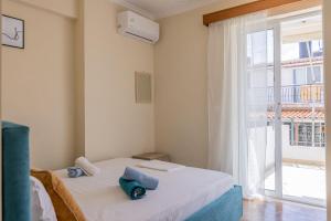 a bedroom with a bed and a large window at Scarlett City Apartment in Zakynthos