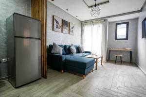 a living room with a blue couch and a refrigerator at Modern flat in Ain Sebaa in Casablanca