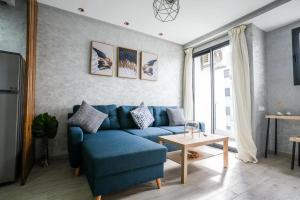 a living room with a blue couch and a table at Modern flat in Ain Sebaa in Casablanca