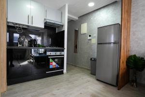 a kitchen with a stainless steel refrigerator and a table at Modern flat in Ain Sebaa in Casablanca