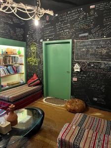a room with a chalkboard wall with a green door at Petra Pottery Hostel in Wadi Musa
