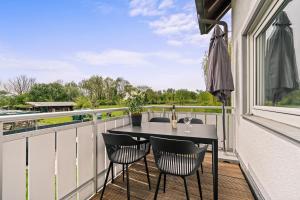 einen Balkon mit einem Tisch und Stühlen sowie einem Fenster in der Unterkunft Ferien-Apartment Seehas mit Privatstrandzugang in Friedrichshafen