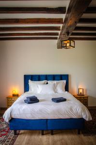 a bedroom with a blue bed with two towels on it at Domaine de Badine, Bordeaux centre 15mn in Saint-Sulpice-et-Cameyrac