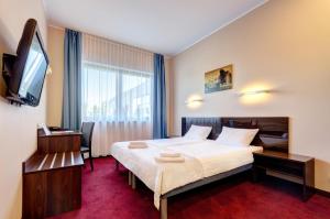 a hotel room with a bed and a television at Focus Hotel Gdańsk in Gdańsk