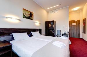a bedroom with a large white bed with white pillows at Focus Hotel Gdańsk in Gdańsk