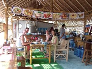 un grupo de personas sentadas en una mesa en un restaurante en Lanta Dareen Garden Home, en Ko Lanta