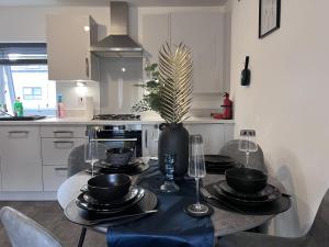 a dining room table with plates and wine glasses on it at Birmingham City 2 Bedroom Apartment in Birmingham