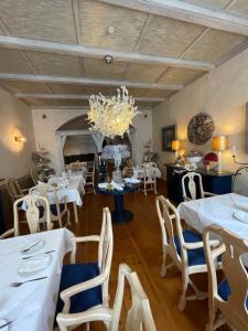 a dining room with white tables and chairs and a chandelier at Haus Wullfcrona in Stralsund