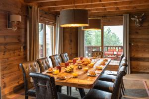 a dining room with a long wooden table and chairs at Chalet de l'Atray in Les Gets