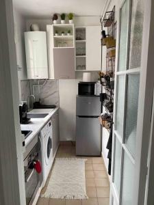 a small kitchen with white cabinets and a washer and dryer at Charmant appartement cosy 2 pièces Paris 15e in Paris