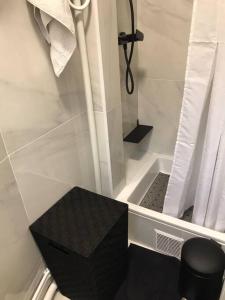 ein Bad mit einer Dusche mit einem schwarzen Stuhl in der Unterkunft Charmant appartement cosy 2 pièces Paris 15e in Paris