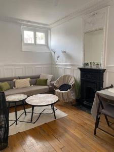 a living room with a couch and tables and a fireplace at Charmant appartement cosy 2 pièces Paris 15e in Paris