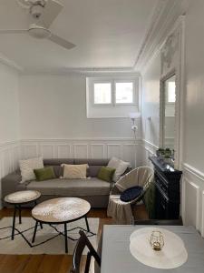 een woonkamer met een bank en 2 tafels bij Charmant appartement cosy 2 pièces Paris 15e in Parijs