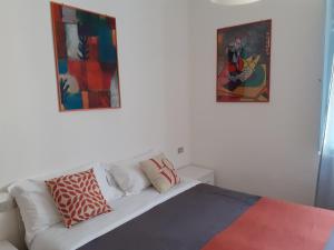リミニにあるHotel Miganiの白いソファ付きのベッドルーム1室、壁に絵画2点