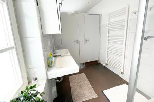 La salle de bains blanche est pourvue d'un lavabo et d'un miroir. dans l'établissement Apartment with balcony in Edingen-Neckarhausen, à Edingen-Neckarhausen