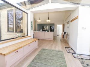 a kitchen with white cabinets and a large window at Castleys in Skipton