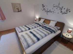 un letto con una coperta blu e bianca sopra di Ferienhaus Gassner a Navis
