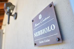 Un cartello metallico su una porta con le parole "nebola" di Agriturismo Cascina Sciulun a Monforte dʼAlba