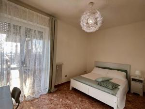 Schlafzimmer mit einem Bett und einem Kronleuchter in der Unterkunft Attico Bellavista in Novate Milanese