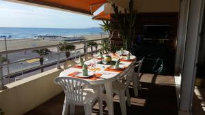 a table on a balcony with a view of the beach at LE PATIO in Canet-en-Roussillon