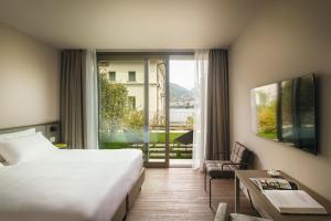 una camera d'albergo con un letto e una grande finestra di Hotel Promessi Sposi a Malgrate