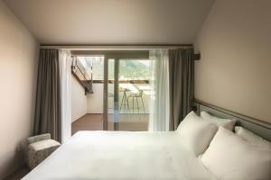 a bedroom with a white bed and a balcony at Hotel Promessi Sposi in Malgrate