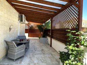 un patio con pergolato in legno, tavolo e sedie. di Kyklades Resort & Spa a Paralimni