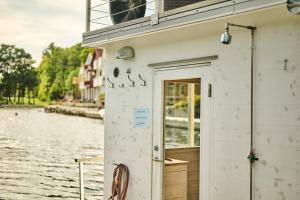 法爾松的住宿－Farsund Resort，白色的建筑,有一扇门,紧靠水体