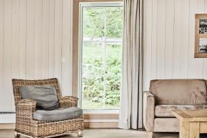 a living room with a chair and a window at Farsund Resort in Farsund