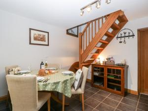 a dining room with a table and a staircase at Little Stables Cottage in Blandford Forum