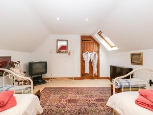 a living room with two beds and a tv at Little Stables Cottage in Blandford Forum