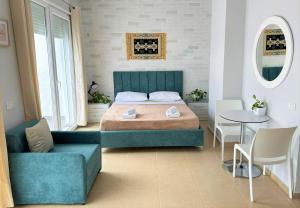 伏罗拉TreA Accomodations - Roof Top On Beach的一间卧室，配有一张床、一张桌子和几把椅子