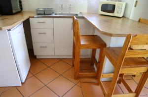 a kitchen with a table and a chair and a sink at Rainbow Glen Self Catering Chalets in Montagu