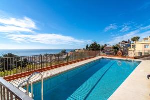 a swimming pool with a view of the ocean at Adosado con vistas al mar desde la piscina con BBQ in Vélez-Málaga