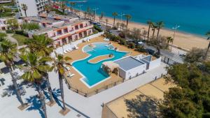 an overhead view of a swimming pool next to the beach at Hotel Club Oustal Del Mar in Le Lavandou