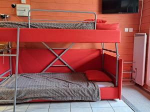 two bunk beds in a room with a red wall at Studio Pra-Loup, 1 pièce, 4 personnes - FR-1-165A-164 in Uvernet