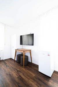 a room with a table and a tv on a wall at Pension Diloyal in Nürtingen