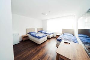 a room with two beds and a table in it at Pension Diloyal in Nürtingen