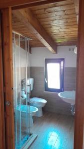 un bagno con due servizi igienici, due lavandini e una finestra di B&B Zurro Room e breakfast a Castellabate